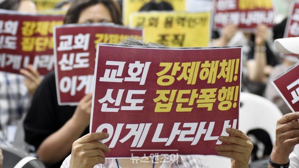 사랑제일교회 교인들이 강제집행을 강행한 조합을 규탄하는 피켓을 들고 있다. 뉴스앤조이 이용필