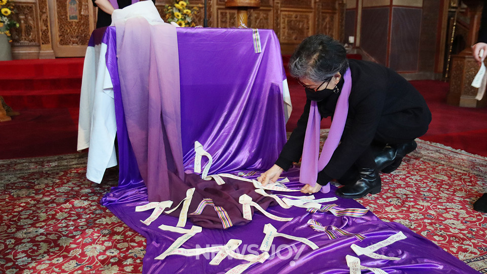 메시지를 적은 베이지색 리본을 놓고 있는 참가자. 뉴스앤조이 나수진