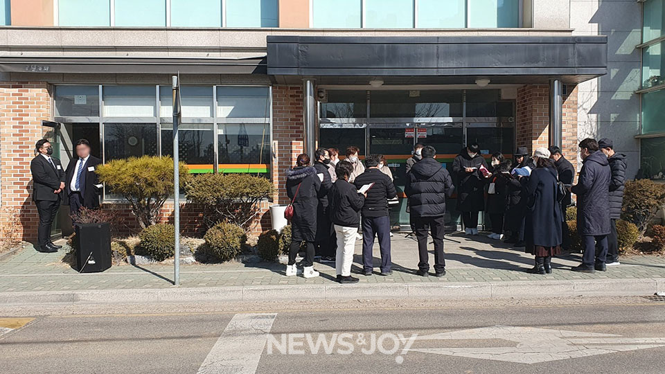 사진 왼쪽에 덩치가 큰 남성 두 명이 카페 출입문을 막고 있다. 박성철 목사와 교인들은 잠긴 예배당 문 앞에서 예배를 할 수밖에 없었다. 뉴스앤조이 자료 사진 