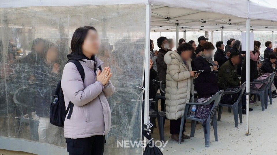 조계사 천막에서 수능 기도회에 참석한 사람들이 기도하고 있다. 학부모들은 사교육비가 부담된다고 입을 모았다. 뉴스앤조이 안디도